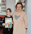 Dziecko pozuje do zdjęcia z instruktorką i dyplomem
